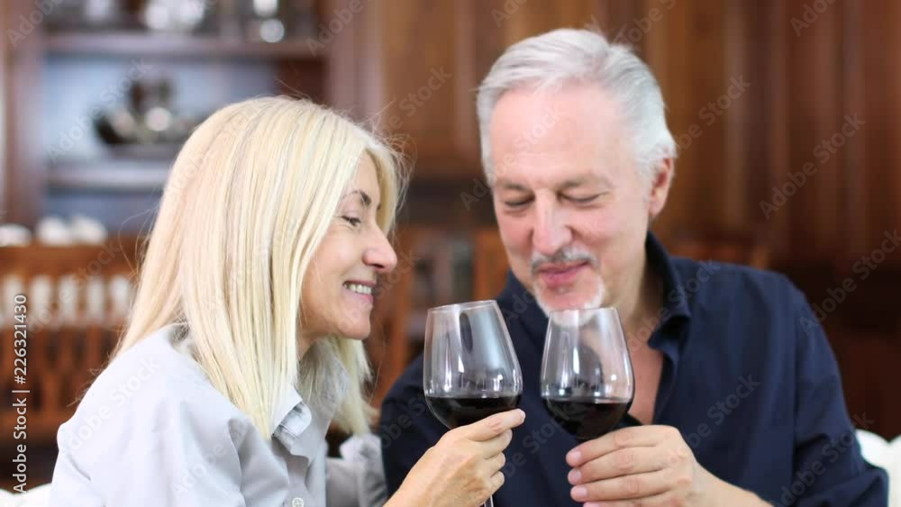 Mature couple toasting wine glasses to celebrate a special occasion Mature couple toasting wine glasses to celebrate a special occasion