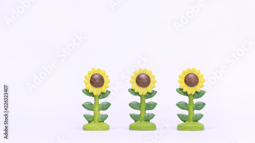 Fototapeta Naklejka Na Ścianę i Meble -  Isolated Three Sunflowers Plastic Model on White Background