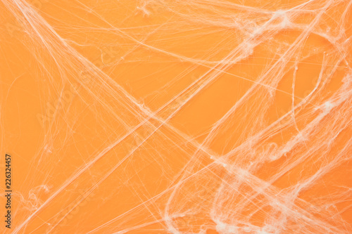 Table top view aerial image of decoration Happy Halloween day background concept.Flat lay accessories essential object to backdrop the white cobweb spider on orange paper.Space for creative design.