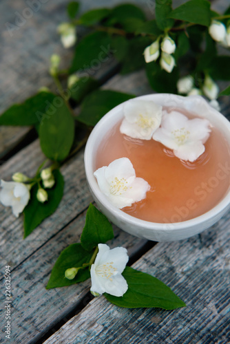 Spa and wellness setting with sea salt, oil essence, jasmin flowers and towels on wooden background. Relax and treatment therapy. photo