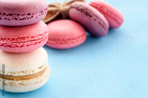 French Macarons on a blue background. Trendy dessert. Sweet cakes. © kulkann