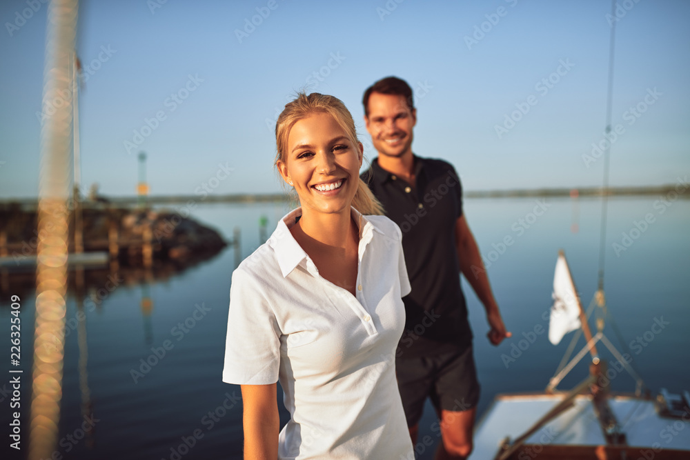 Smiling young woman standing with her husband on their yacht