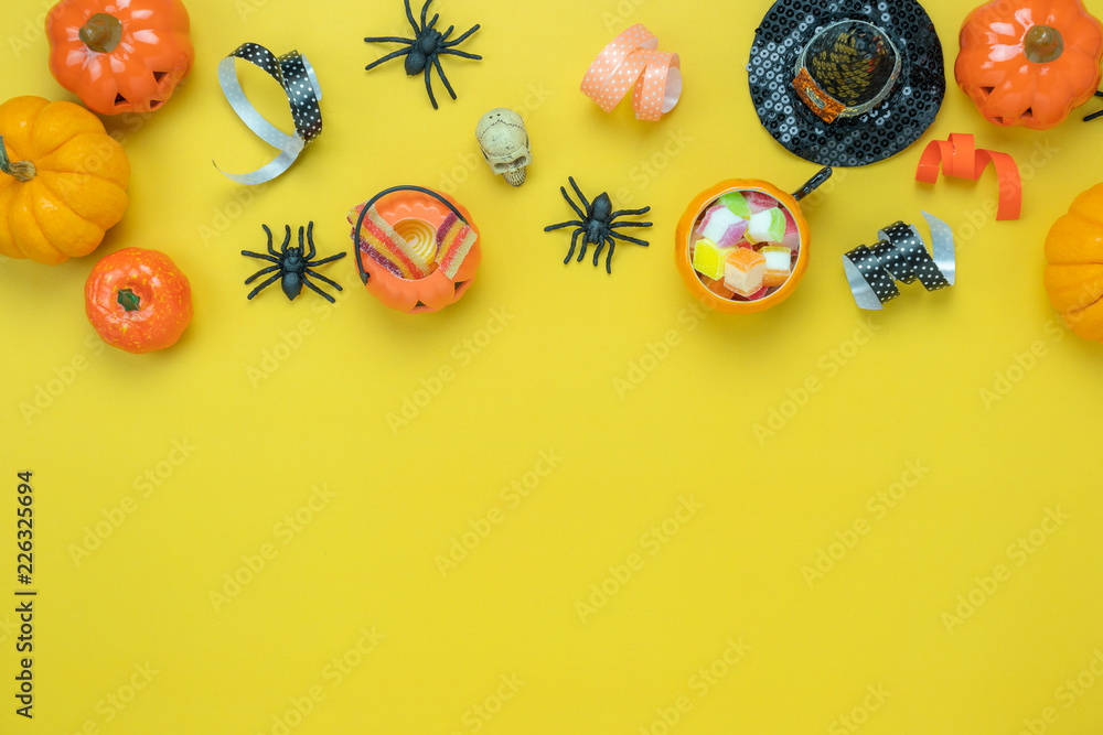 Table top view aerial image of decoration Happy Halloween day background concept.Flat lay accessories essential object to party the pumpkin & sweet candy on yellow paper.Space for design mock up. Table top view aerial image of decoration Happy Halloween day background concept.Flat lay accessories essential object to party the pumpkin & sweet candy on yellow paper.Space for design mock up.