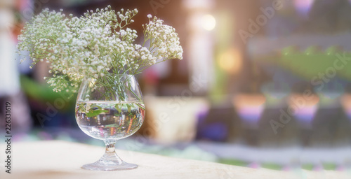 White flower in glass on dinner table