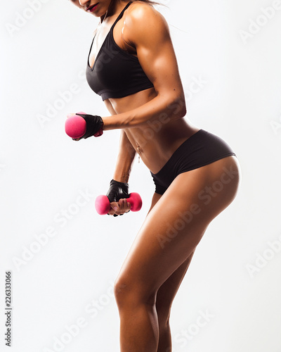 Perfect Fitness Body of Beautiful Woman. Fitness Instructor in Sports Clothing. Female Model with Fit Muscular and Slim Body in Sportswear doing Workout. Young Fit Girl Lifting Dumbbells.