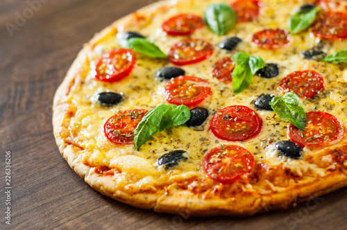 Pizza Margherita or Margarita with Mozzarella cheese, tomato, olive. Italian pizza on wooden background