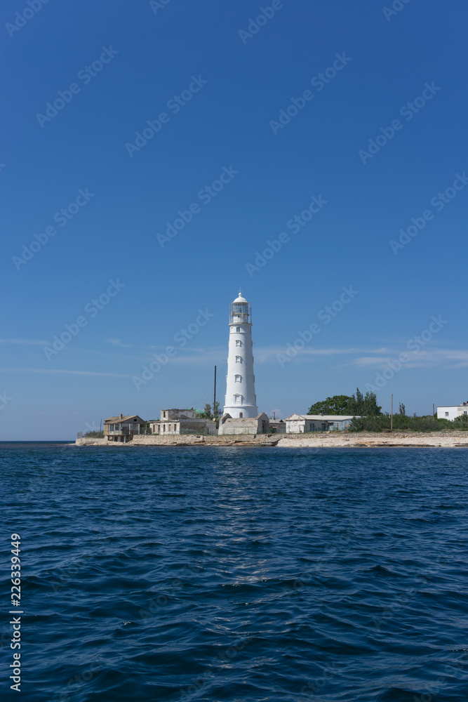 Marine landscape with views of the Cape Tarhankut and the white lighthouse against the sky.