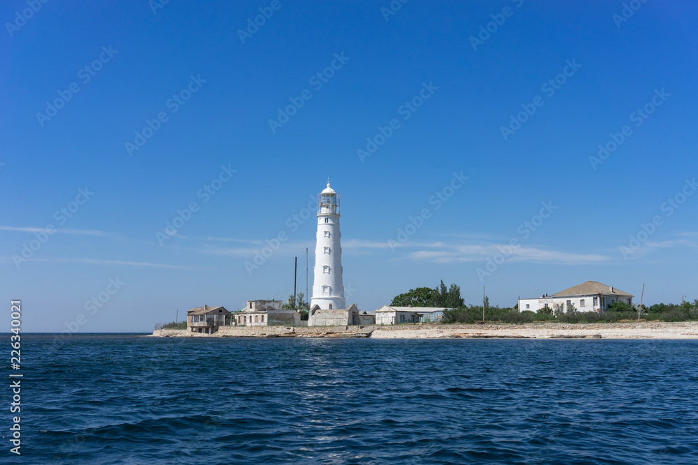 Marine landscape with views of the Cape Tarhankut and the white lighthouse against the sky.