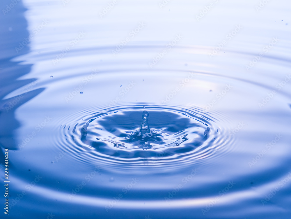 close up drop of water on blue background close up drop of water on blue background