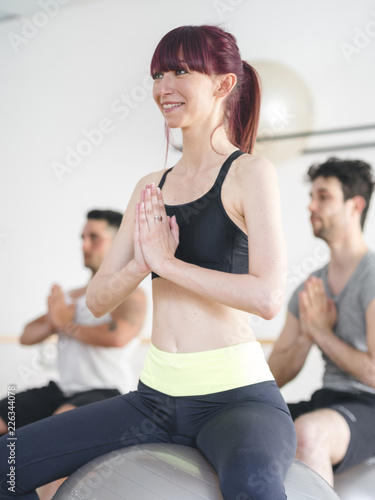 young people doing a yoga lesson with a gym ball