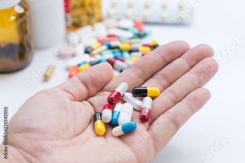 Selective focus Drugs in hand. Senior man holding assorted capsules and pills in his hand. Conceptual of health care for the elderly.