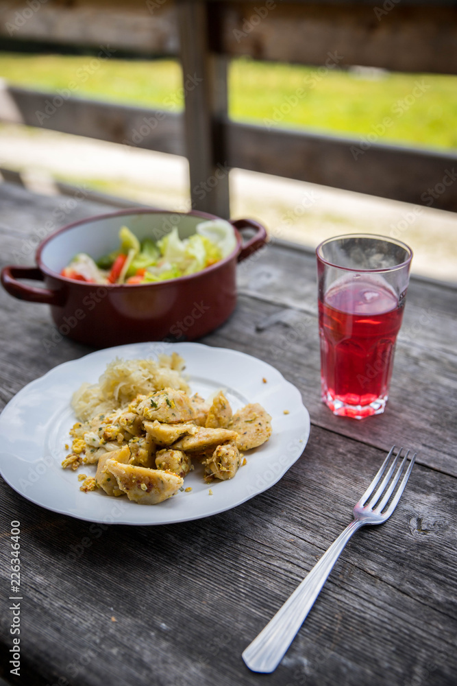 Mahlzeit auf der Alm: Knödel mit Sauerkraut und Salat