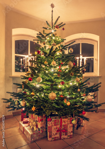 Festive Christmas tree with garland lights, gifts and decoration