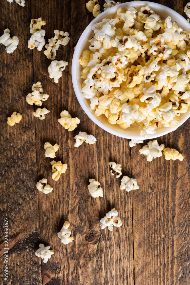 Air salty popcorn.A bowl of popcorn on a wooden table.Salt popcorn on the wooden background . With space for text.Top view.popcorn texture.Chees . Air salty popcorn.A bowl of popcorn on a wooden table.Salt popcorn on the wooden background . With space for text.Top view.popcorn texture.Chees .