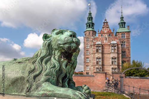 Photography Tower spires over lion bronze sculpture guard at the entrance of Rosenborg Castle, built in 17th century