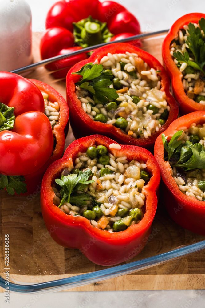 Stuffed peppers in a glass baking dish, ready for baking in the oven. healthy vegan cuisine for the whole family. comfort food Stuffed peppers in a glass baking dish, ready for baking in the oven. healthy vegan cuisine for the whole family. comfort food