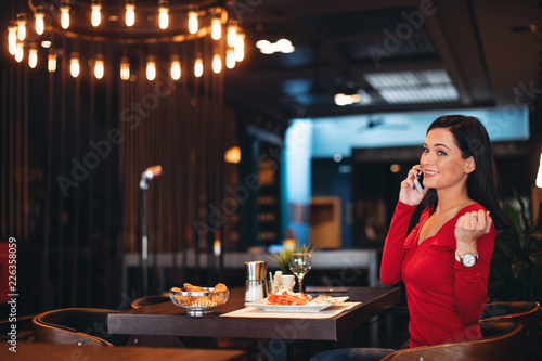 Young woman on breakfast talking on the phone in a restaurant