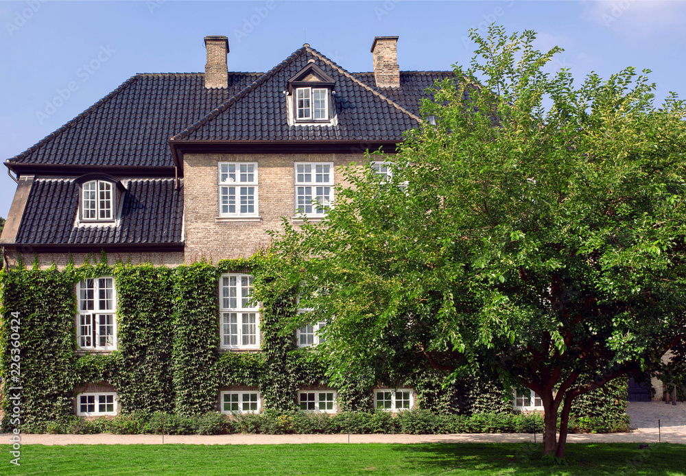 Garden around the beautiful brick walls of historical house in Copenhagen, Denmark. Traditional architecture Garden around the beautiful brick walls of historical house in Copenhagen, Denmark. Traditional architecture