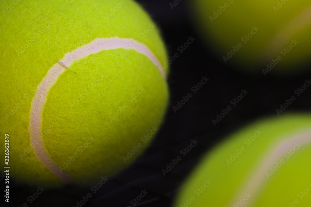 part of new yellow tennis balls on black background