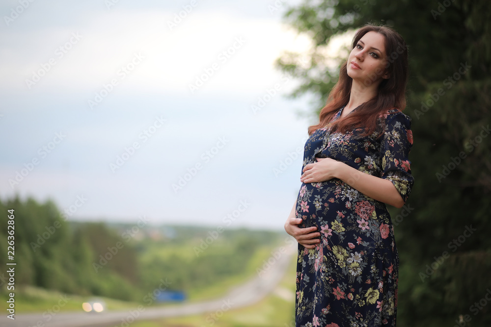 Pregnant girl in a dress in nature Pregnant girl in a dress in nature