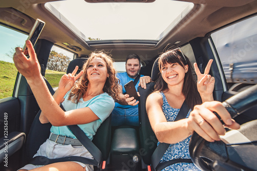 road trip group of people making selfie in the car