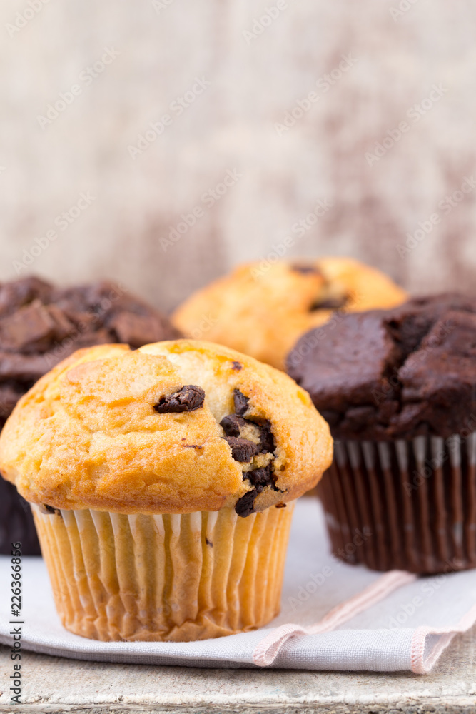 Homemade muffins with chocolate, vintage background.