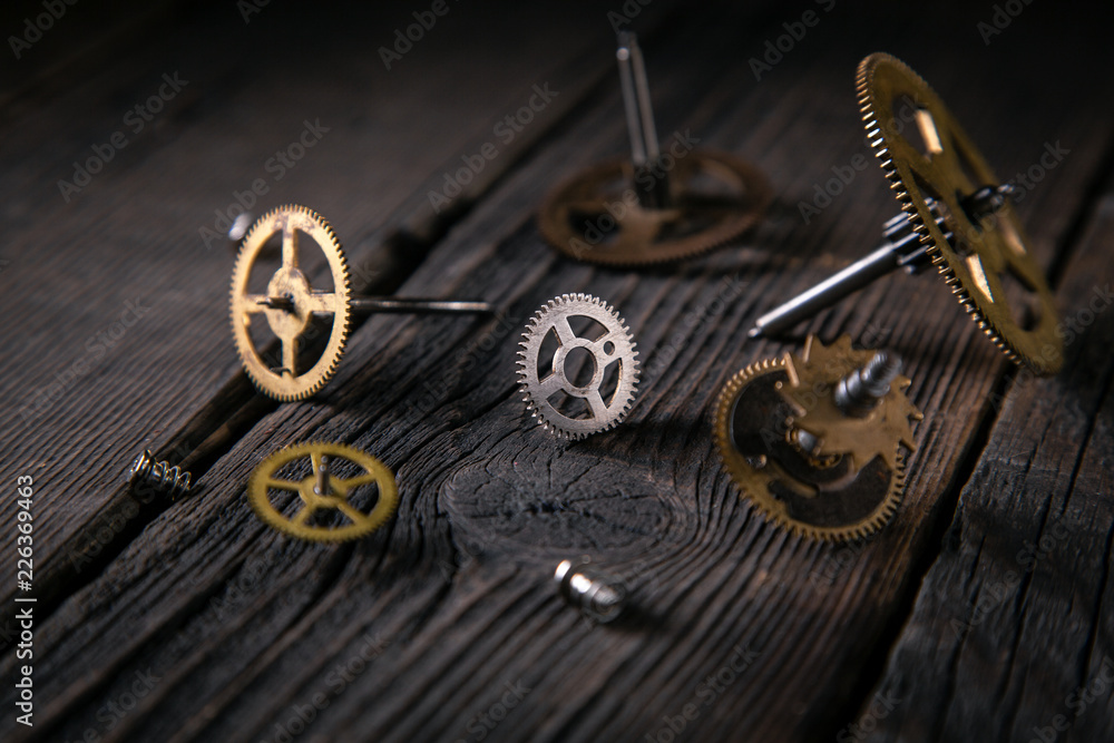 Obraz premium Clockwork gears of time bronze on wooden table. Concept time and ideas support