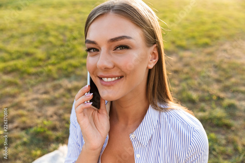 Close up of cheerful young girl talking on mobile phone