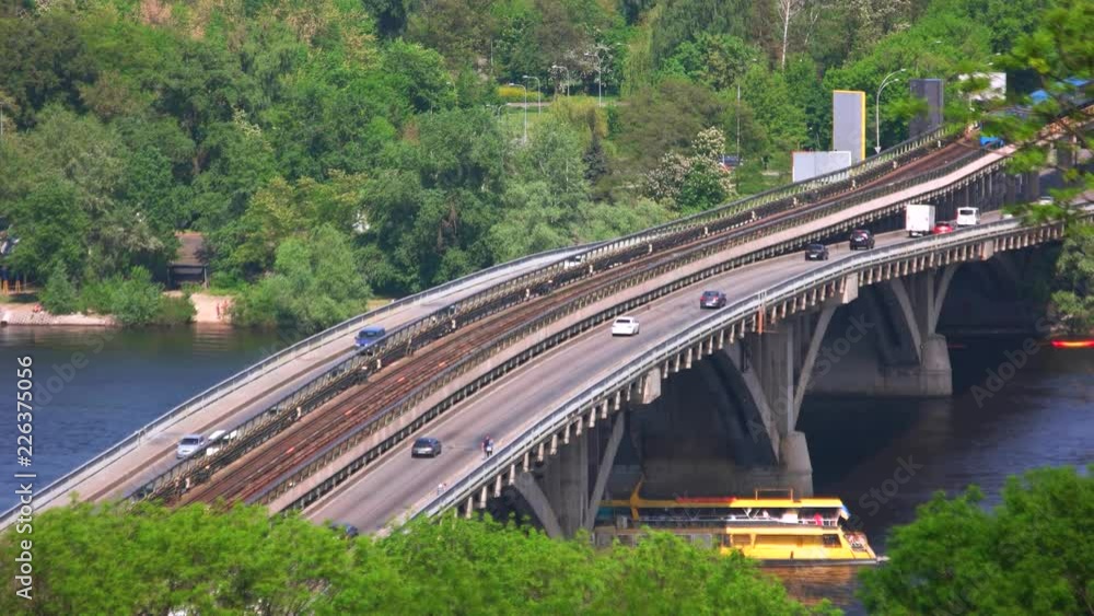 Highway bridge and car traffic. Ship under bridge. Warm sunny day. Highway bridge and car traffic. Ship under bridge. Warm sunny day.
