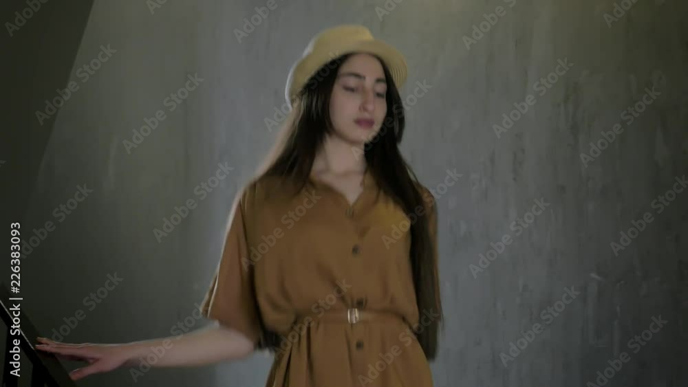 young beautiful girl go for a walk on the city. she is wearing a Stylish hat and Summer Dresses and carrying a handbag. she go down some stairs and out of the frame. young beautiful girl go for a walk on the city. she is wearing a Stylish hat and Summer Dresses and carrying a handbag. she go down some stairs and out of the frame.