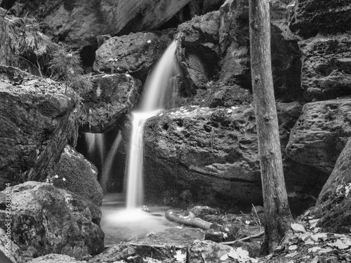 Schwarz-weiß Aufnahme eines kleinen Wasserfalls an einem Gebirgsbach. photo