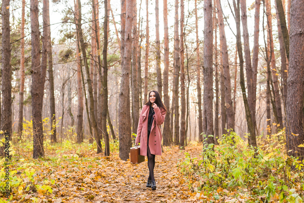Weather, season, people concept - young woman in pink coat over the autumn nature background Weather, season, people concept - young woman in pink coat over the autumn nature background