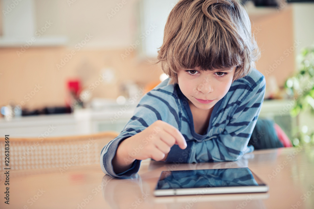 Little boy playing with digital tablet.