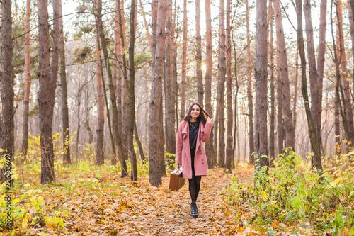 Fall, season and people concept - young woman walking in park at autumn © satura_