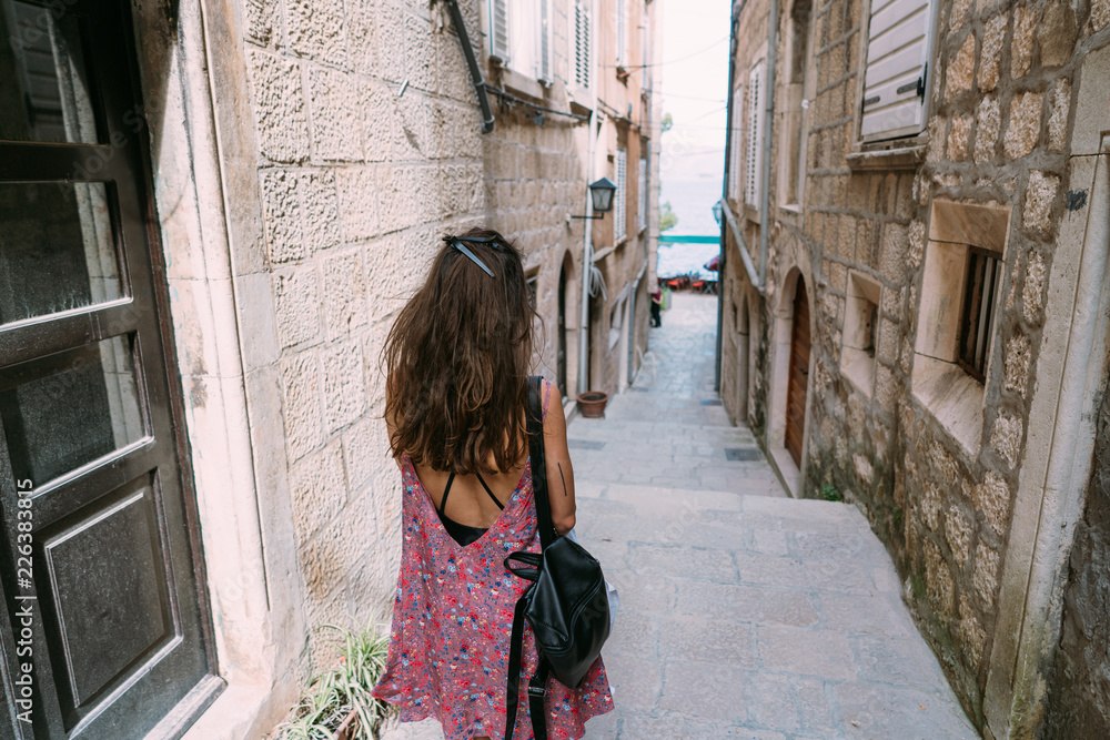 A young girl walks along a narrow Italian street