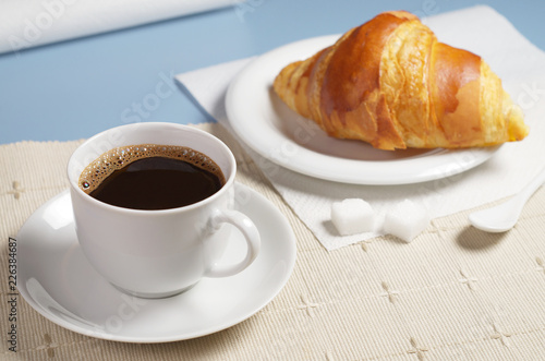 Coffee with croissant on table