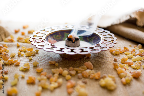 Frankincense burning on a hot coal. Frankincense is an aromatic resin, used for religious rites, incense and perfumes, incense smoke