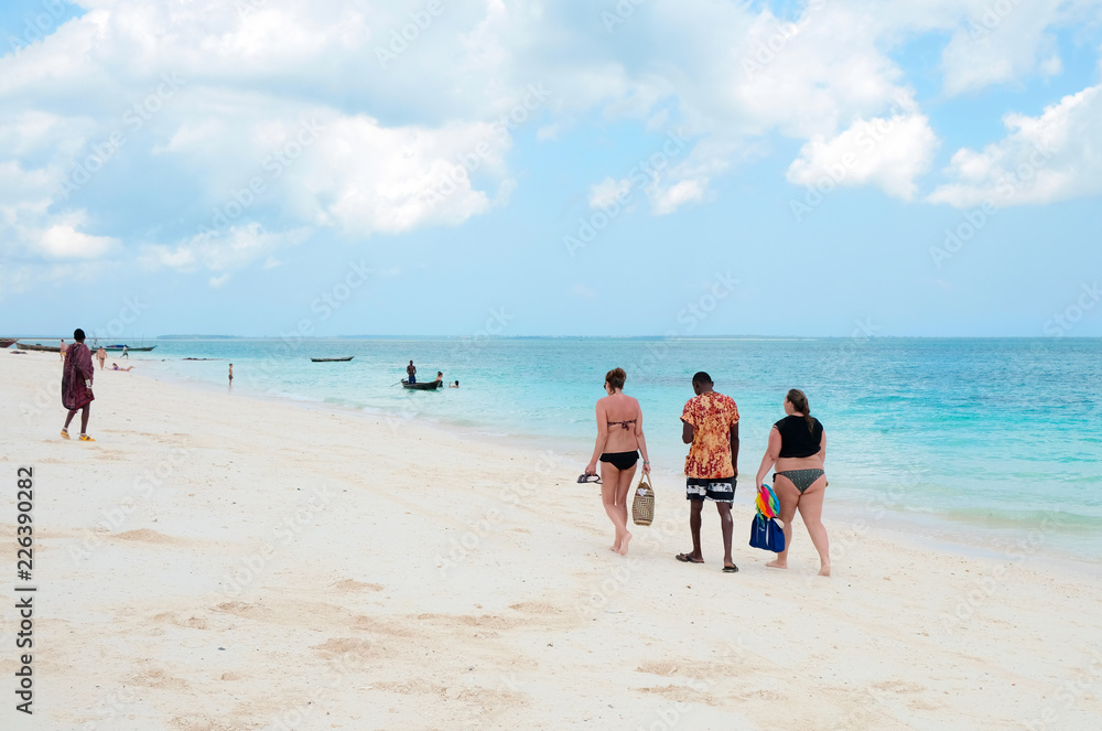 Thick and slender women stroll along the beach with local guide Zanzibar