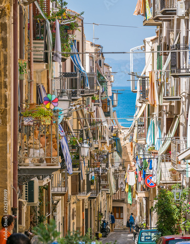 Fototapeta Naklejka Na Ścianę i Meble -  A cozy street in Cefalù on a sunny summer day. Sicily, southern Italy.
