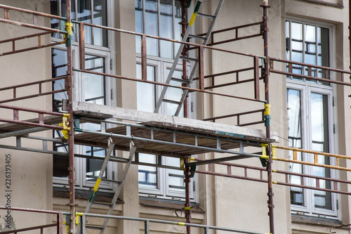 Tall building under construction with scaffolds closeup
