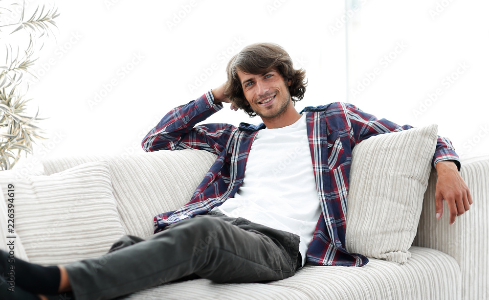 serious modern guy sitting on the couch serious modern guy sitting on the couch
