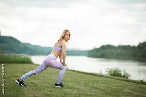 beautiful young girl doing exercises in the summer near the river © Alexandr