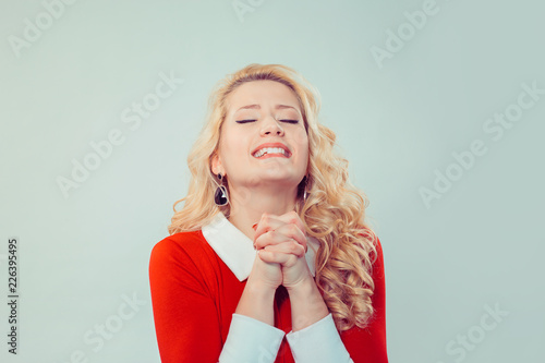 Beautiful woman pleading with hands together