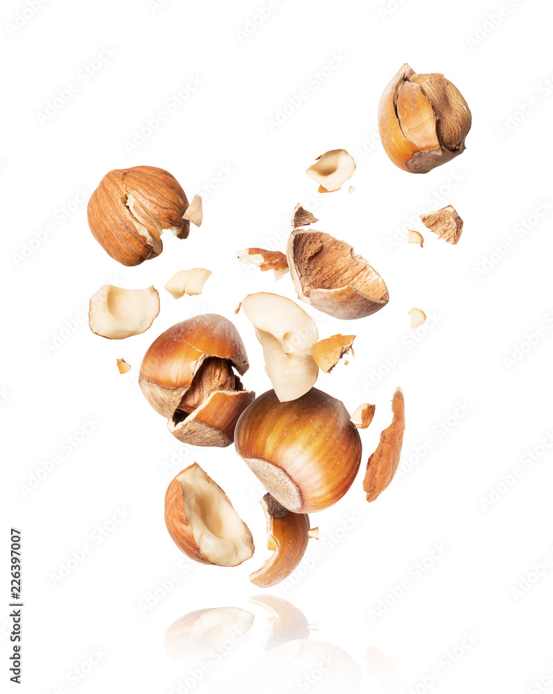 Hazelnuts crushed in the air close-up, isolated on white background Hazelnuts crushed in the air close-up, isolated on white background