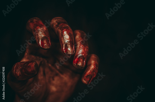 Bloody dirty zombie hand on black background. Halloween spooky poster