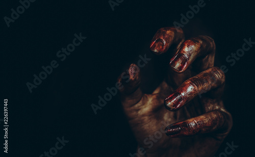 Bloody dirty zombie hand on black background. Halloween spooky poster