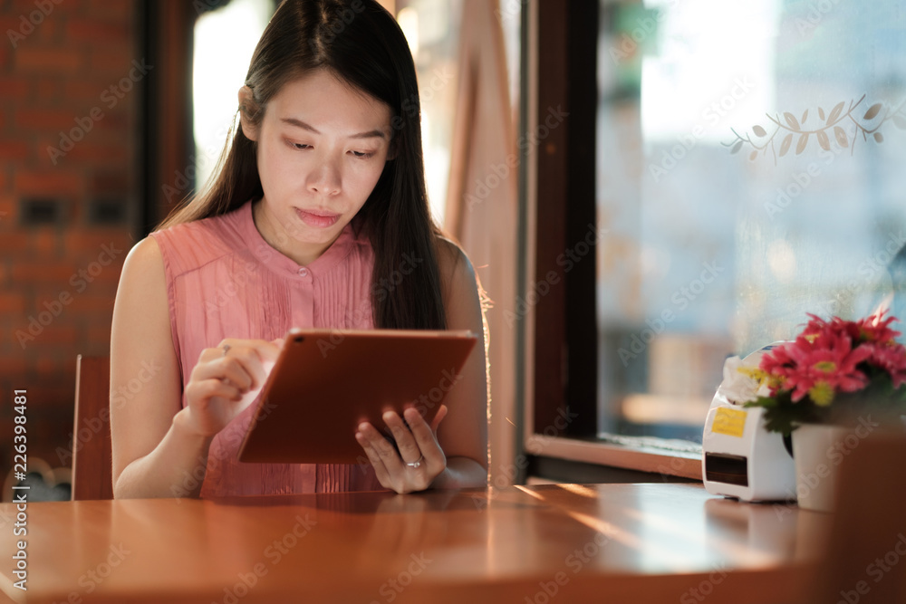 Woman looking on her tablet for social network in coffee cafe. Woman looking on her tablet for social network in coffee cafe.