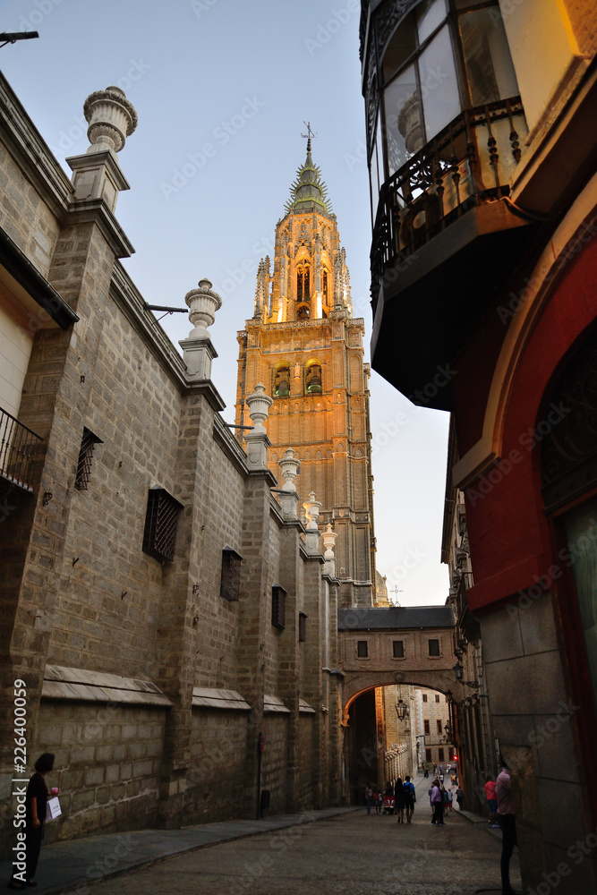 Toledo, Spain - September 24, 2018: Street of the Arch of Palace next to the tower of the Santa Iglesia Catedral Primada de Toledo.
