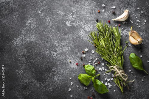 Spices and herbs over black stone table. 