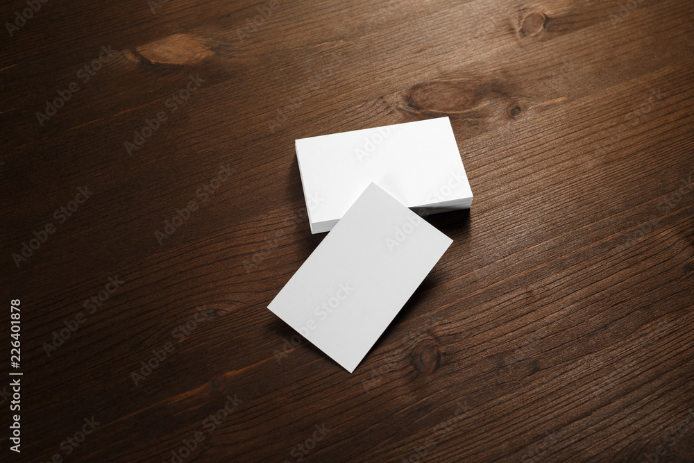 Blank white business cards on wood table background. Mockup for branding identity. Blank white business cards on wood table background. Mockup for branding identity.